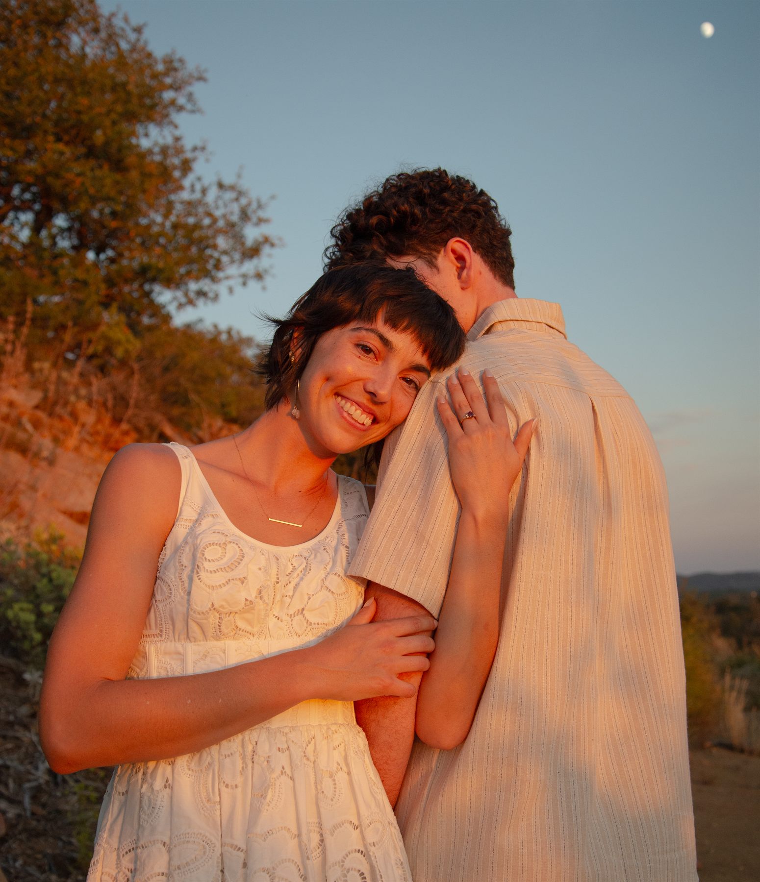 Lisa resting her head on Ezra&rsquo;s shoulder at sunset