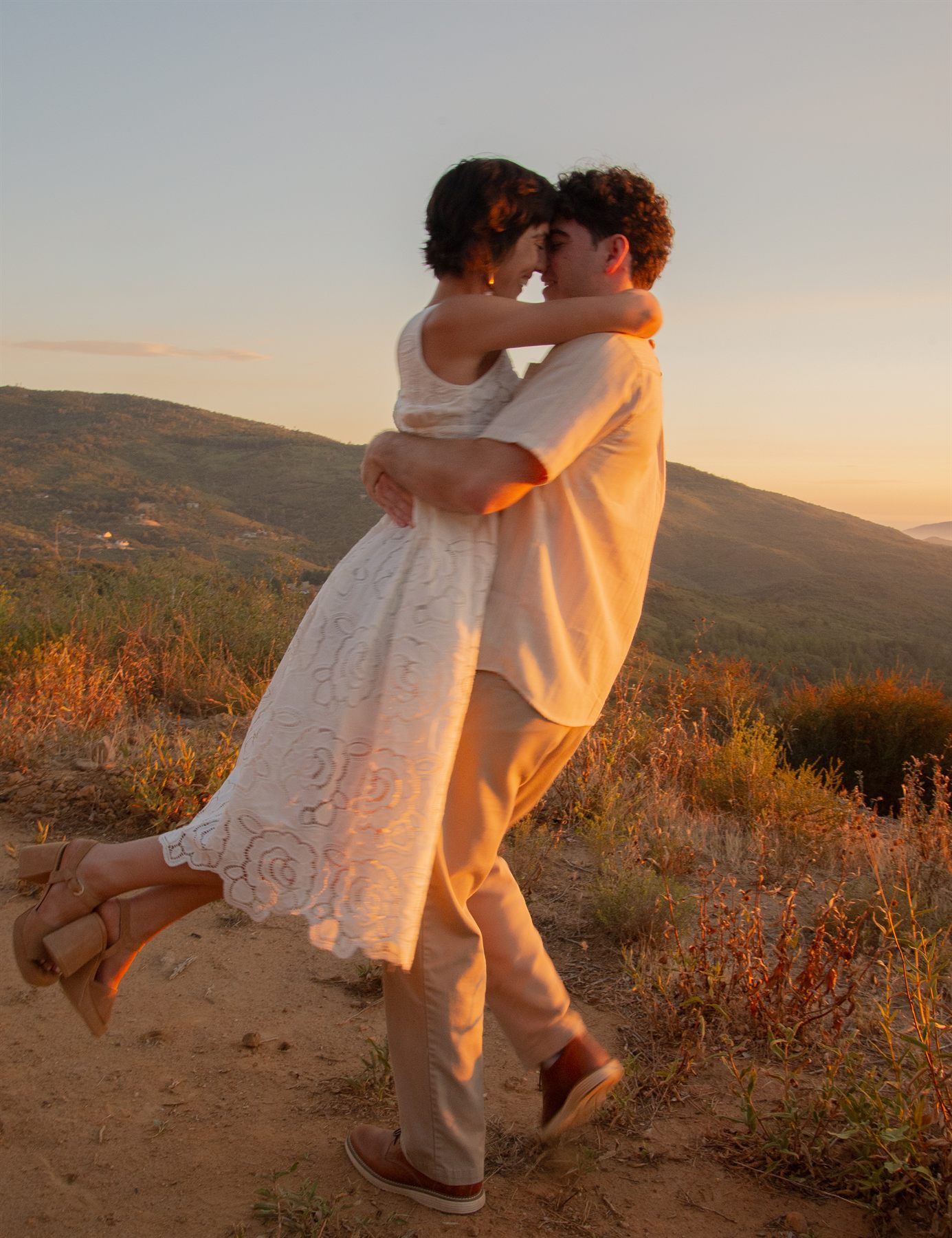 Ezra lifting Lisa on the trail at dusk